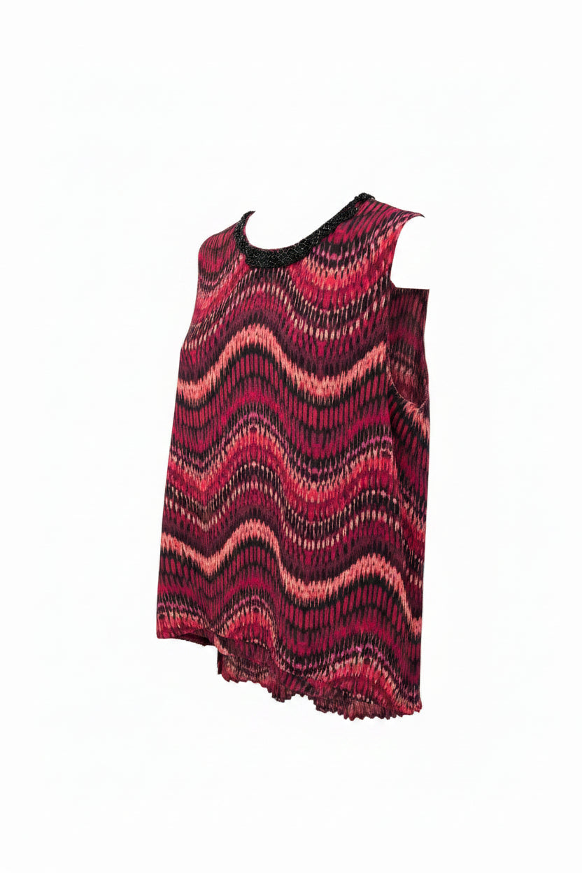 A sleeveless high-low top with a wavy abstract pattern in red, pink, and black.