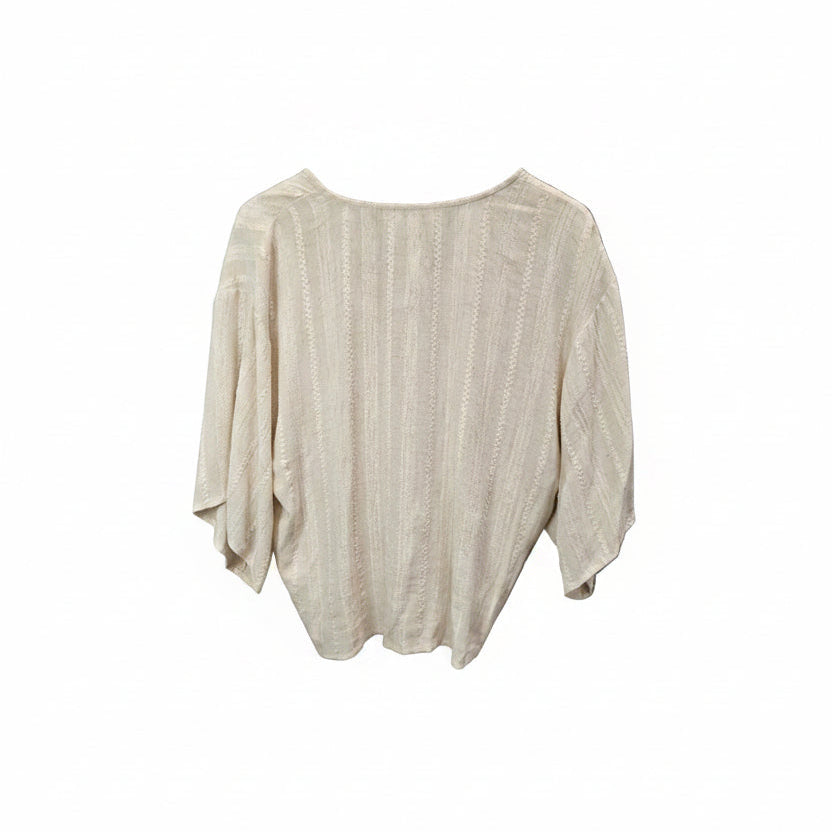 A light beige textured knit top with three-quarter sleeves and a wide boat neckline.