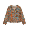 A women's long-sleeve blouse with an orange, blue, and white floral pattern.