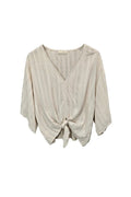 An off-white textured blouse with a V-neckline and front knot detail.
