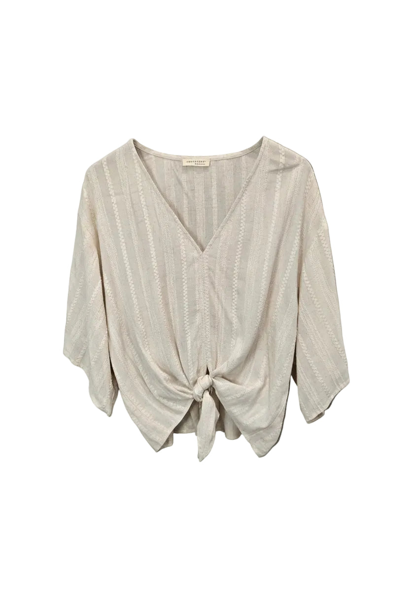 An off-white textured blouse with a V-neckline and front knot detail.